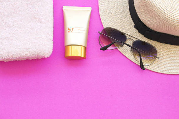 Naturalne Kosmetyki dla skóry twarzy sunscreen spf50 i okulary kapelusz ręcznik styl życia kobiety relaksu lato na tle różowy - Zdjęcie, obraz