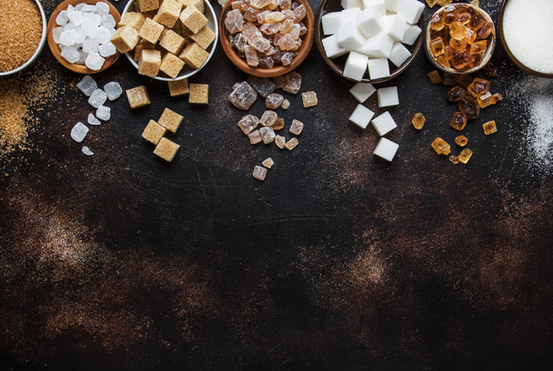 Set of different white and brown sugar in assortment, dark background, top view - Foto, afbeelding