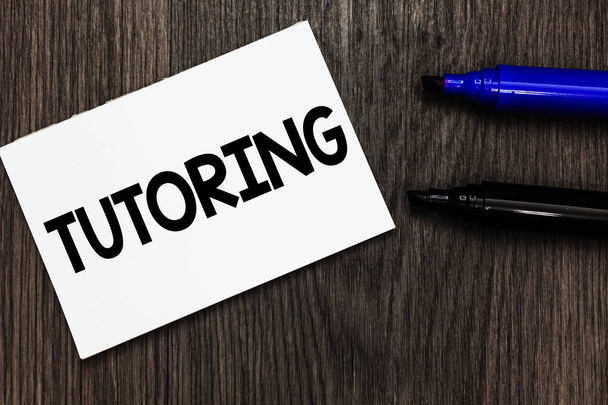 Text sign showing Tutoring. Conceptual photo An act of a person employed to administer knowledge to someone Important idea ideas notebook marker markers wooden background reminder - Photo, Image