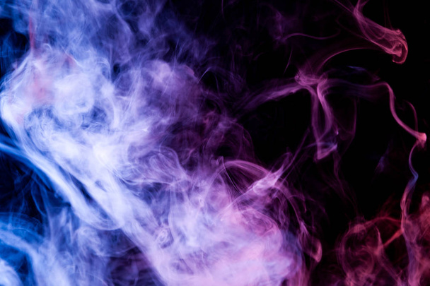 Blauw en paars wolk rook op zwarte geïsoleerde achtergrond - Foto, afbeelding