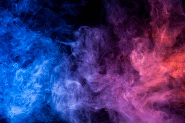 Πυκνοί καπνοί πολύχρωμα χρώματα μπλε και μωβ σε μαύρο φόντο απομονωμένες. Υπόβαθρο του καπνού vap - Φωτογραφία, εικόνα