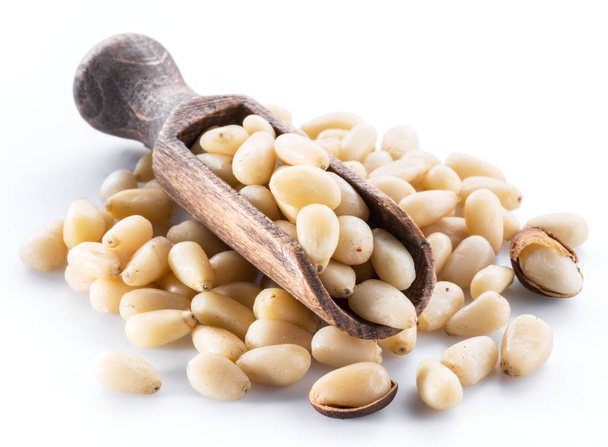 Pine nuts in the wooden scoop. White background. - Foto, imagen