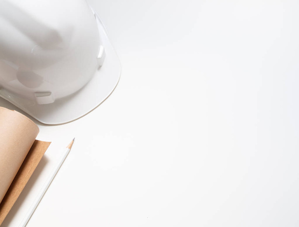 flat lay capacete de segurança branco duro com papel e lápis para o trabalhador de engenharia isolado no fundo branco vista superior com espaço
. - Foto, Imagem