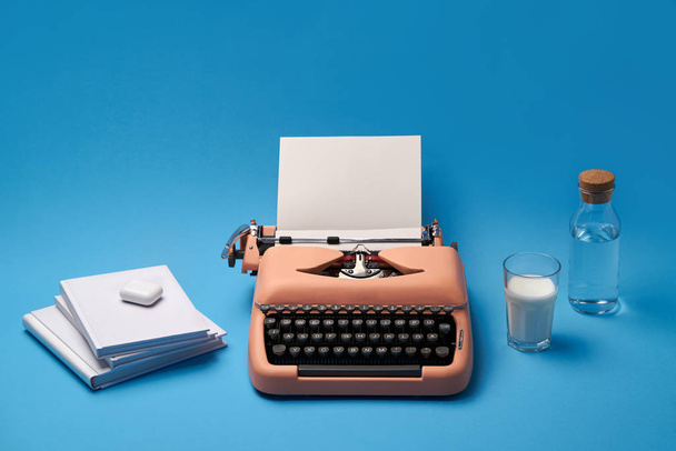 Composición con máquina de escribir, libros, vidrio y botella
 - Foto, imagen