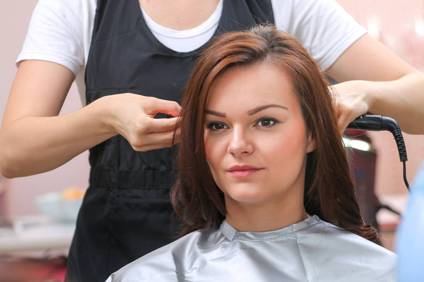 Lány, miközben egy fodrász kozmetika szárítsuk meg a haját - Fotó, kép