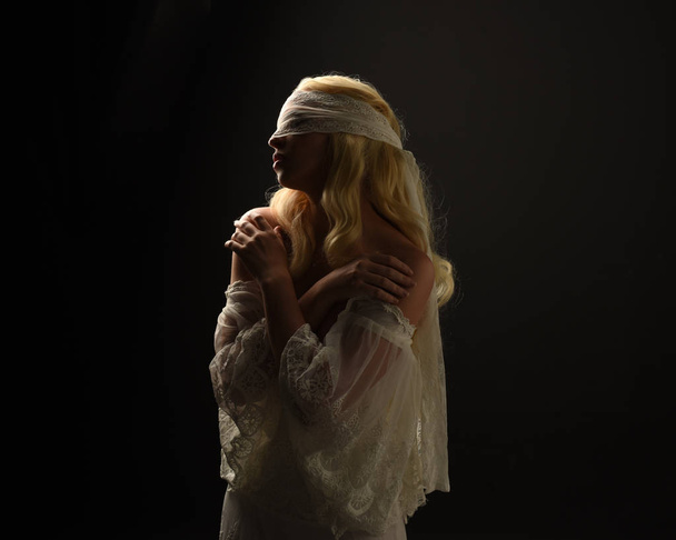 portret Blondynka dziewczyna ubrana w białej sukni koronki i opaskę. czarny studio tło. - Zdjęcie, obraz