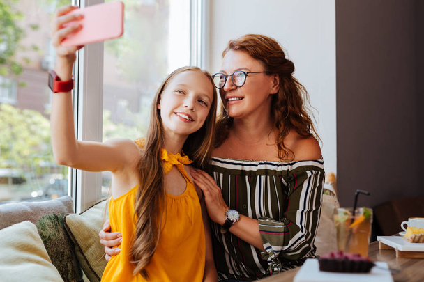 Modern teenage girl making selfie with mother - Valokuva, kuva