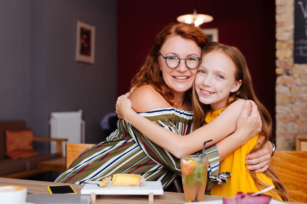Loving mother and daughter spending their morning in cafe - Photo, Image
