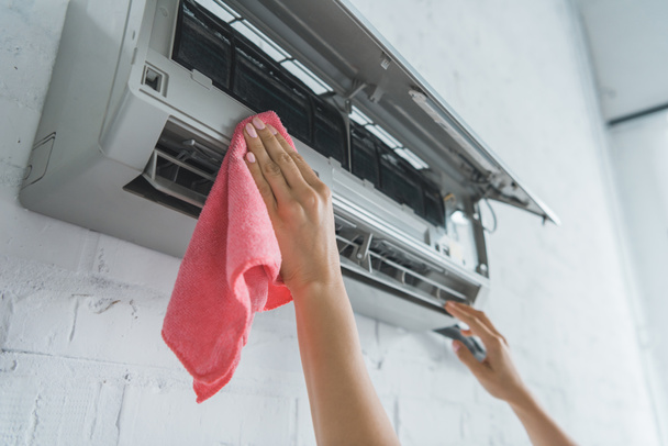 oříznutý pohled zaměstnankyně čištění klimatizace s hadr - Fotografie, Obrázek