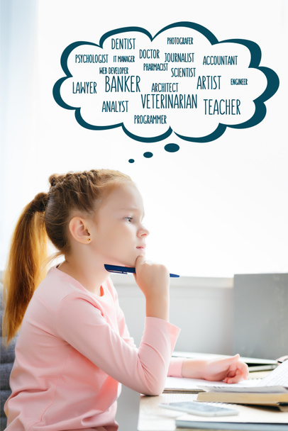 side view of thoughtful schoolgirl holding pen and looking away while studying with words of different professions in speech bubble - Foto, Imagen