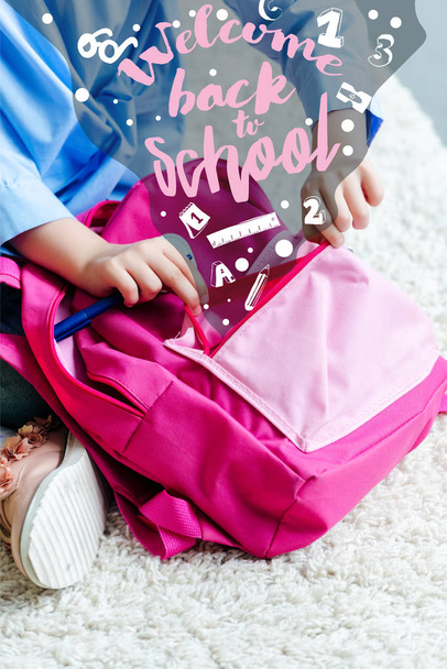 cropped shot of child packing pink school bag at home, welcome back to school - Fotó, kép