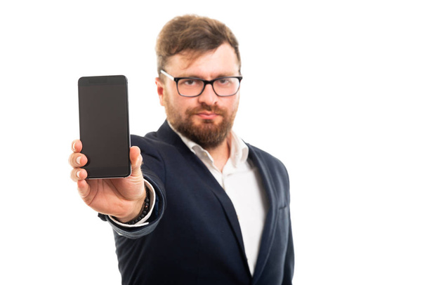 Πορτρέτο του επιχείρηση άνθρωπος δείχνει smartphone με την κάμερα που απομονώνονται σε λευκό φόντο με copyspace διαφήμιση περιοχή - Φωτογραφία, εικόνα