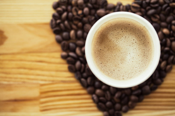 Dobré ráno. Papírové šálek kávy s Coffee Bean na dřevěný stůl. - Fotografie, Obrázek