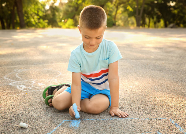 Cute little boy drawing with chalk, outdoors - Φωτογραφία, εικόνα
