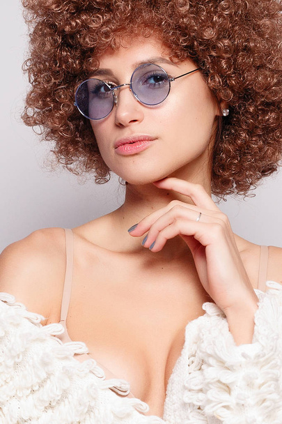 Portrait of smiling young black woman. Portrait of a beautiful young woman with African American afro haircut and glamor makeup. Studio shot. Attractive girl wearing eyeglasses. - 写真・画像