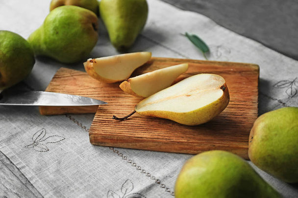 Wooden board with cut pear on table - Fotoğraf, Görsel