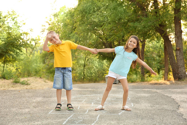 Cute little children playing hopscotch, outdoors - Foto, imagen
