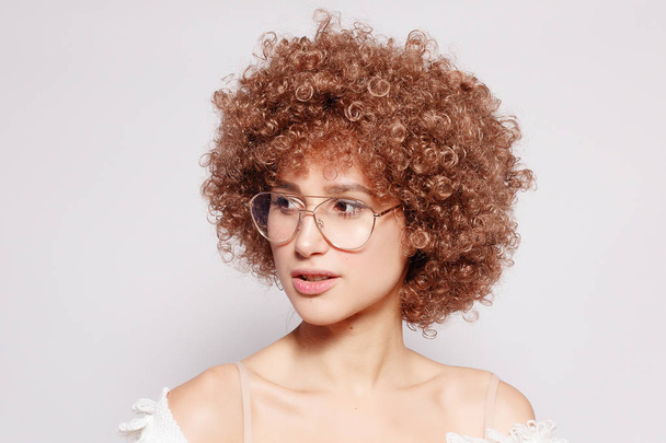 Portrait of smiling young black woman. Portrait of a beautiful young woman with African American afro haircut and glamor makeup. Studio shot. Attractive girl wearing eyeglasses. - Fotografie, Obrázek