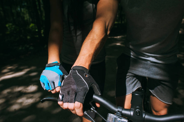Hands of a  in a sports  gloves holding on to the steering wheel of the bicycle. Close-up. - 写真・画像
