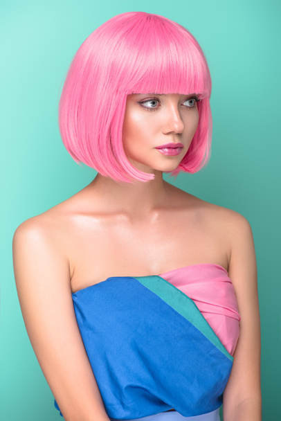 beautiful young woman with pink bob cut looking away isolated on turquoise - Foto, immagini