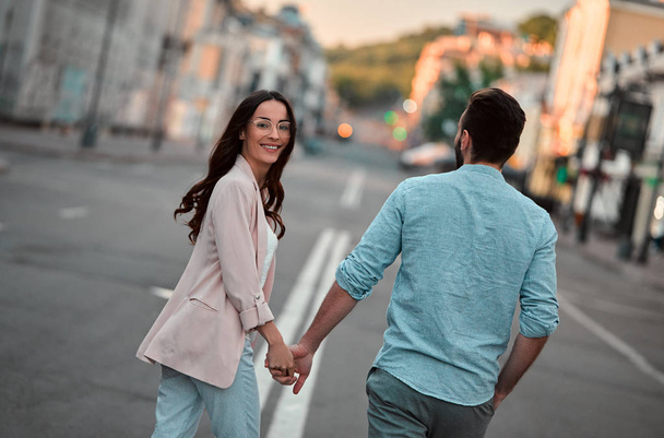 Love is in the air! Cute romantic couple spending time together in the city. Handsome bearded man and attractive young woman are in love. - Foto, Bild