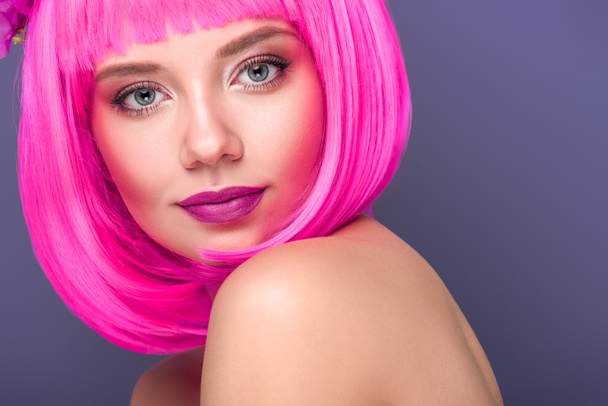 close-up portrait of beautiful young woman with pink bob cut looking at camera isolated on violet - Fotografie, Obrázek