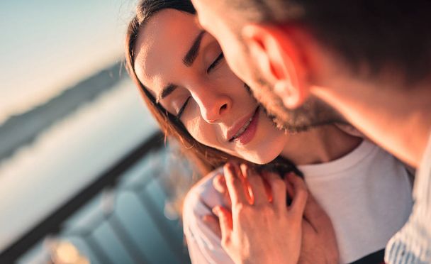 Love is in the air! Cropped image of cute romantic couple spending time together in the city. Handsome bearded man and attractive young woman are in love. Hugging, kissing and having fun during the sunset. - Fotoğraf, Görsel