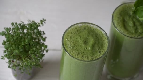 Karışık yeşil smoothie maddeler veya beyaz arka plan, metin, çiğ gıda detoks kavramı için bir yer ile kahvaltı vegan kokteylde - Video, Çekim