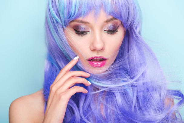 close-up portrait of beautiful young woman with curly blue hair isolated on blue - Φωτογραφία, εικόνα