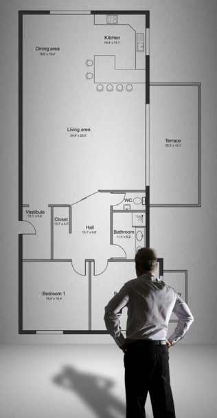Бізнесмен дивиться концепцію плану квартири, намальовану на стіні
 - Фото, зображення