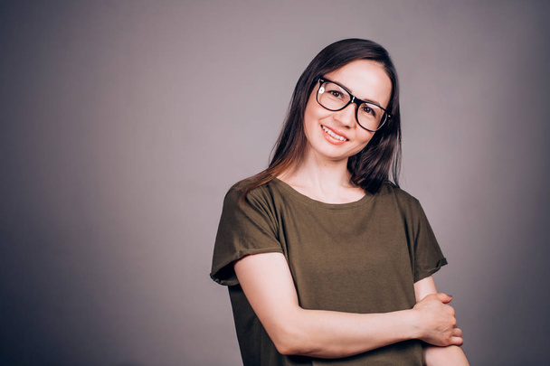 Beautiful young business woman in glasses with smile looking at camera on grey background. Youth, student, happiness concept - Foto, immagini