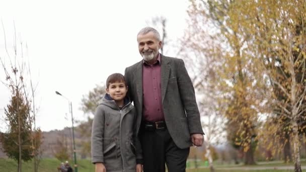 Opa und Enkel verbringen Zeit miteinander im Park. Sie gehen im Park spazieren und jubeln - Filmmaterial, Video