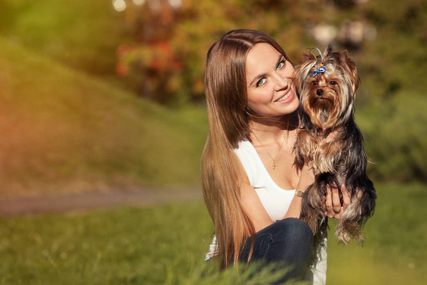 Mädchen mit langen Haaren hält einen Hund - Foto, Bild