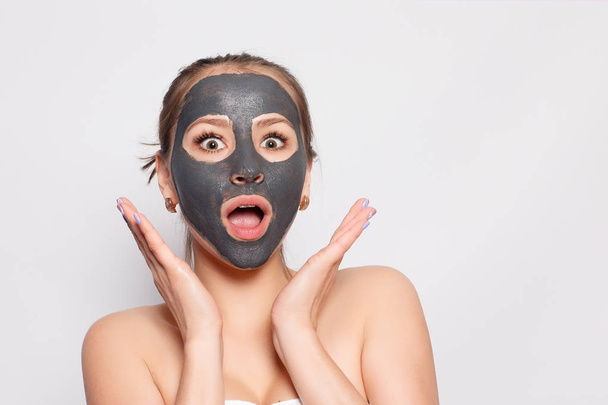 Woman Face Mask. Portrait Of Beautiful Girl Removing Cosmetic Black Peeling Mask From Facial Skin. Closeup Of Attractive Young Woman With Natural Makeup And Cosmetic Peel Mask On Face. High Resolution - Foto, imagen