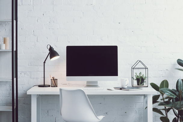 computer, white table, chair and plants in modern workplace - Photo, Image