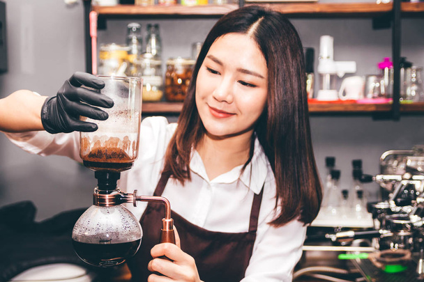 Женщины Бариста делает кофе на сифон кофеварка в кафе
 - Фото, изображение