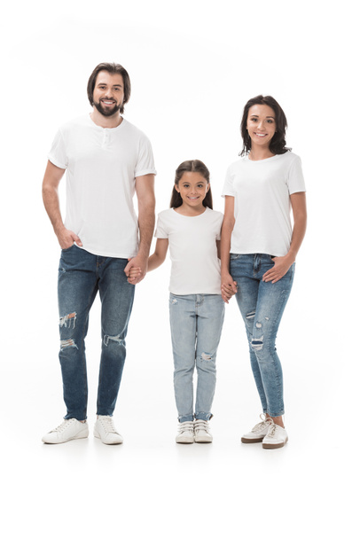 glimlachend familie in witte shirts hand in hand en kijken naar camera geïsoleerd op wit - Foto, afbeelding