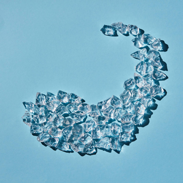 pattern of refreshing ice cubes on blue background, dolphin shape  - Photo, Image