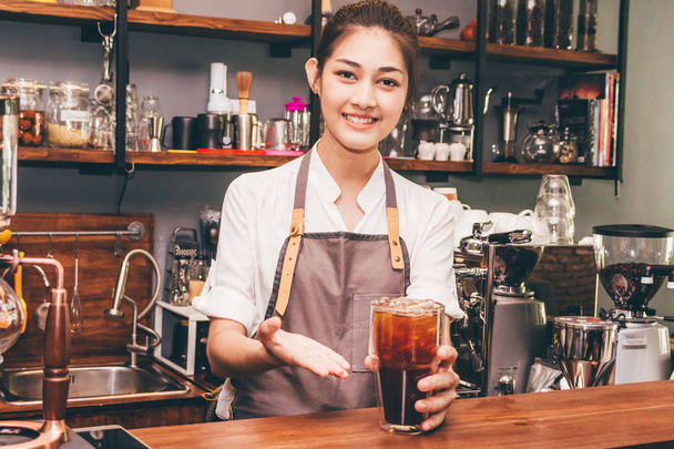 Γυναίκα barista δίνοντας καφέ σε πελάτη στο καφενείο - Φωτογραφία, εικόνα