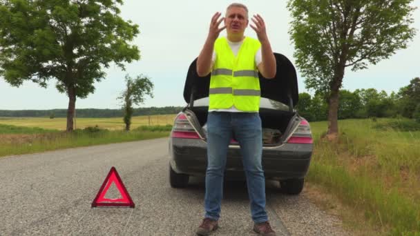 Πρόγραμμα οδήγησης θυμωμένος κοντά σπασμένο αυτοκίνητο στο δρόμο - Πλάνα, βίντεο