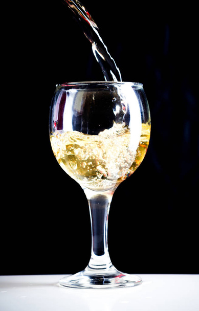White wine pouring in glass, close up - Фото, изображение