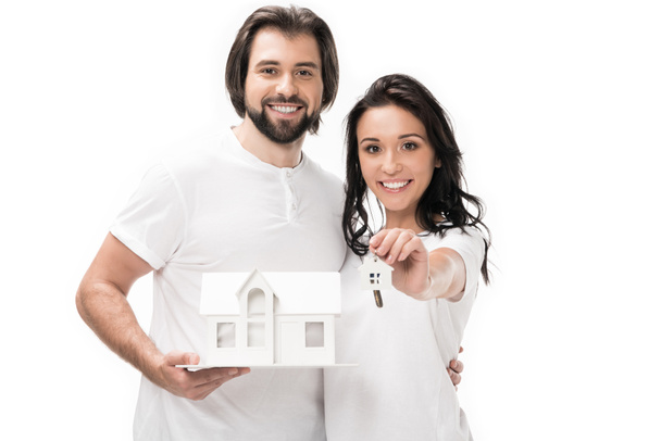 portrait of smiling couple with house model and keys isolated on white - Foto, Bild