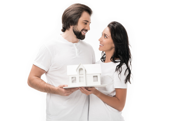 ritratto di coppia sorridente con modello di casa isolato su bianco
 - Foto, immagini
