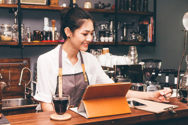 Бариста женщина с помощью цифровых планшетных вычислений в кафе счетчик бар
 - Фото, изображение