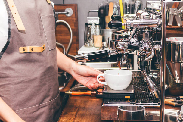 Mujer Barista utilizando máquina de café para hacer café en la cafetería
 - Foto, Imagen