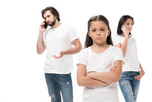enfoque selectivo del niño molesto y los padres hablando en teléfonos inteligentes aislados en blanco
 - Foto, imagen