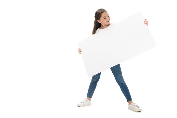 niño sonriente con pancarta en blanco en las manos aisladas en blanco
 - Foto, Imagen