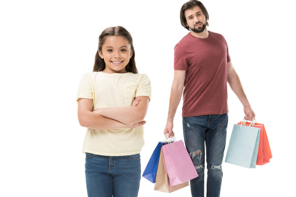 selective focus of smiling kid and tired father with shopping bags isolated on white - Photo, Image