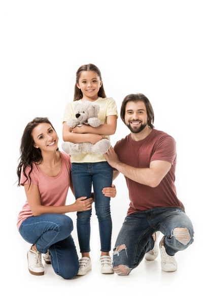 smiling parents and daughter with teddy bear isolated on white - Photo, Image