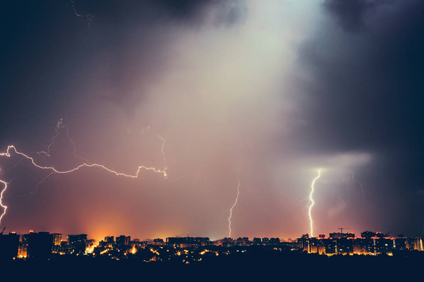 Thunderstorms vivid dramatic cloudy sky and lightnings above night city - Photo, Image